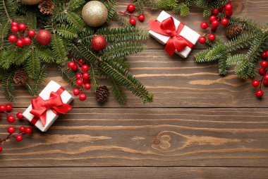 Hediye kutularıyla Noel ağacı dalları ve ahşap arka planda Rowan