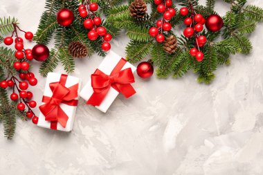 Hediye kutularıyla Noel ağacı dalları ve beyaz grunge arka planında Rowan.