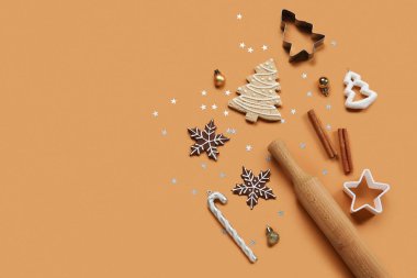 Noel kurabiyeleri, kabartma kalıpları ve kahverengi arka planda merdane.