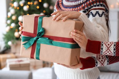 Noel arifesinde arkadaşından hediye paketi alan kadın, yakın plan.