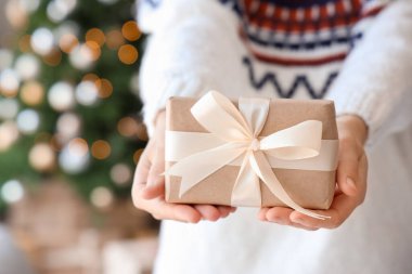 Noel arifesinde evde hediye paketi veren kadın, yakın plan.