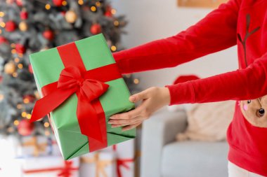 Noel arifesinde evde hediye paketi veren kadın, yakın plan.