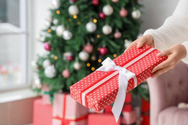 Noel arifesinde evde hediye paketi veren kadın, yakın plan.