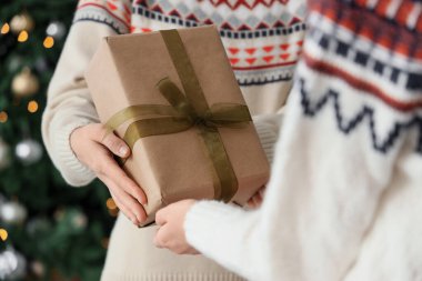 Noel arifesinde arkadaşından hediye paketi alan kadın, yakın plan.