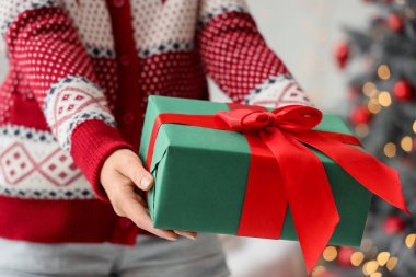 Noel arifesinde evde hediye paketi veren kadın, yakın plan.