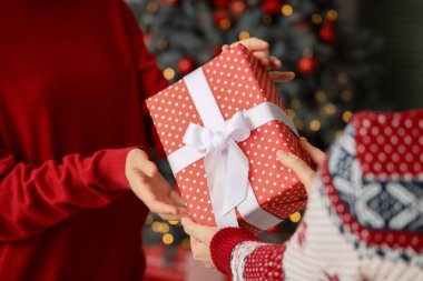 Noel arifesinde arkadaşından hediye paketi alan kadın, yakın plan.