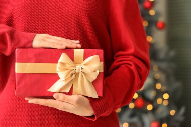 Noel arifesinde elinde hediye kutusu olan kadın, yakın plan.
