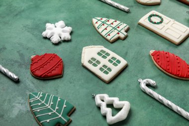 Tatlı Noel kurabiyeleri ve yeşil arka planda süslemeleri olan kompozisyon