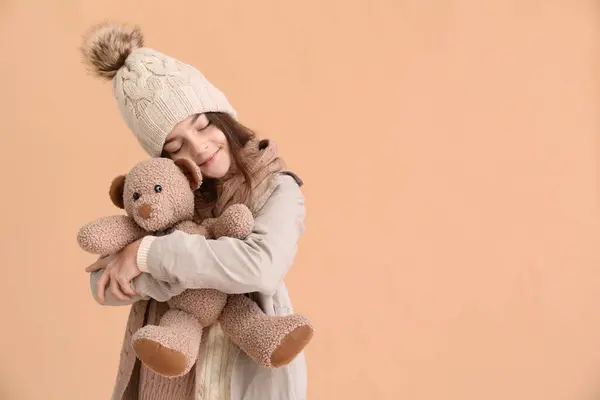 Nettes Kleines Mädchen Winterkleidung Mit Spielzeugbär Auf Beigem Hintergrund — Stockfoto