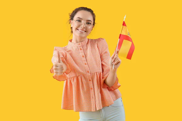 Красива Молода Жінка Прапором Іспанії Показує Великий Палець Жовтому Тлі — стокове фото