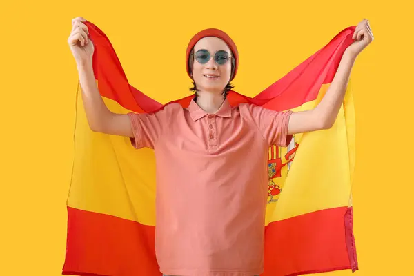 黄色の背景にスペインの旗を持つ十代の少年 — ストック写真