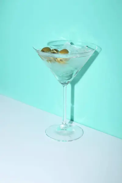 オリーブと色の背景に氷とマティーニのグラス — ストック写真