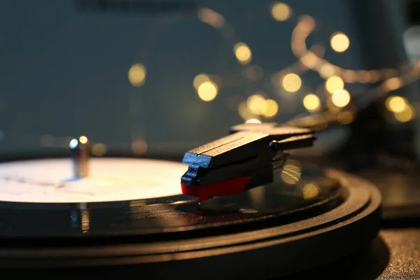 Record player with vinyl disk and glowing lights, closeup