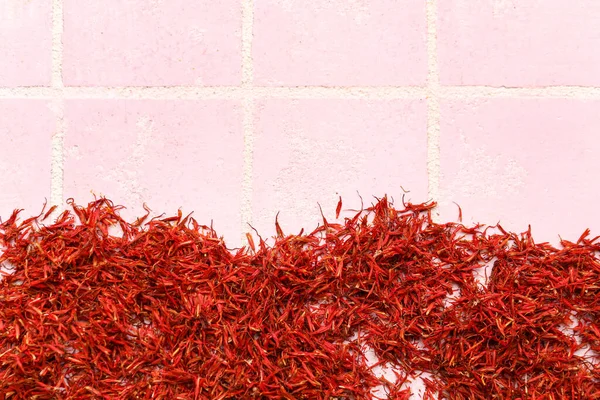 Pile of saffron on pink tile background
