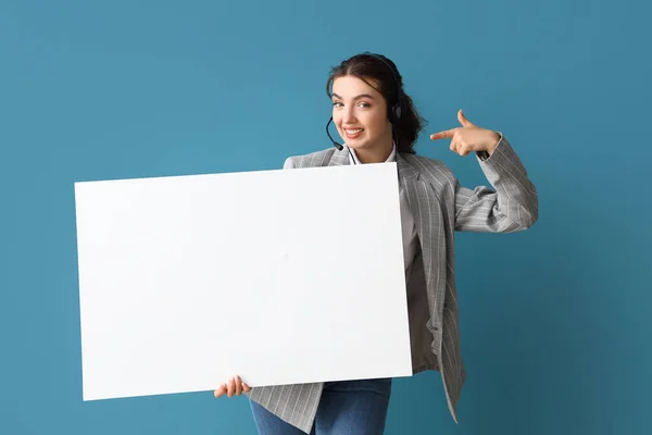 Female technical support agent with blank poster on blue background