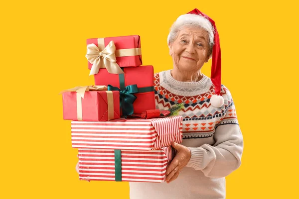 Senior Mikulás Kalap Karácsonyi Ajándékok Sárga Háttér — Stock Fotó