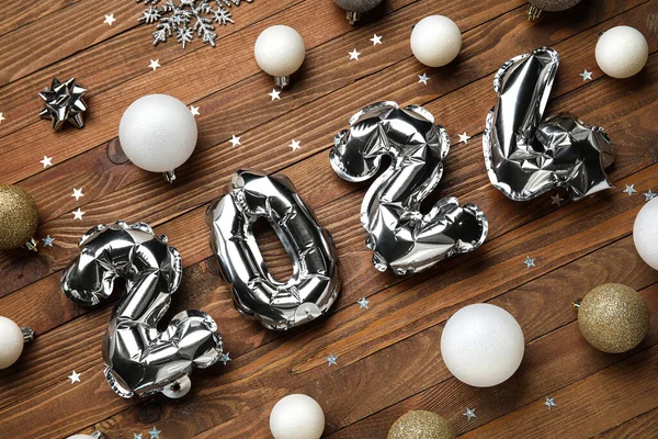Figure 2024 Made Foil Balloons Christmas Balls Wooden Background — Stock Photo, Image