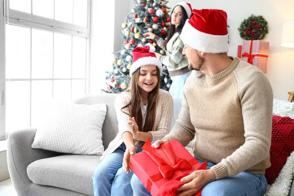 Mutlu baba, küçük kızını Noel hediyesiyle karşılıyor.
