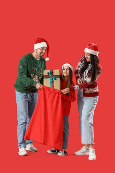 Kırmızı Arka Planda Noel Hediyeleriyle Dolu Mutlu Bir Aile — Stok fotoğraf