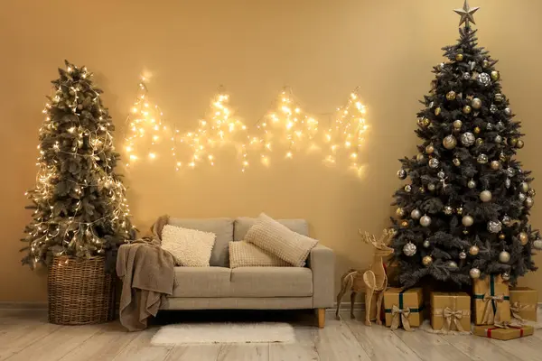 Innenraum Des Wohnzimmers Mit Weihnachtsbäumen Grauem Sofa Und Leuchtenden Lichtern — Stockfoto