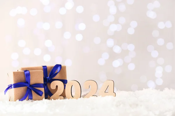 Figuur 2024 Met Geschenkdozen Sneeuw Tegen Wazig Licht — Stockfoto