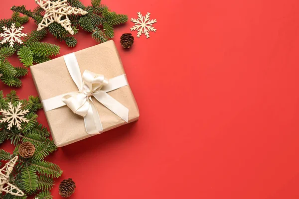 圣诞树分枝 附有礼品盒和红色背景的装饰品 — 图库照片