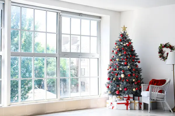 圣诞树下的礼品盒和节日期间的白色扶手椅 — 图库照片