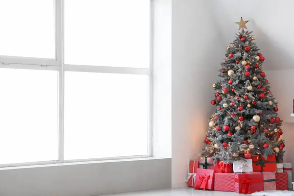 クリスマスツリーと暖炉の下にギフトボックス付きのお祝いのリビングルームのインテリア — ストック写真