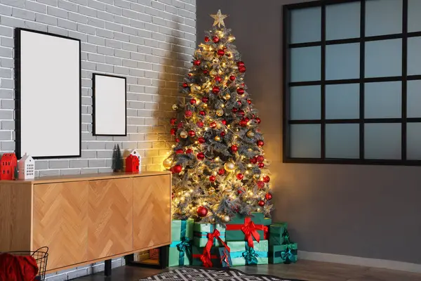 木製のキャビネットとクリスマスツリーの下のギフト用の箱が付いているお祝いの部屋の内部 — ストック写真