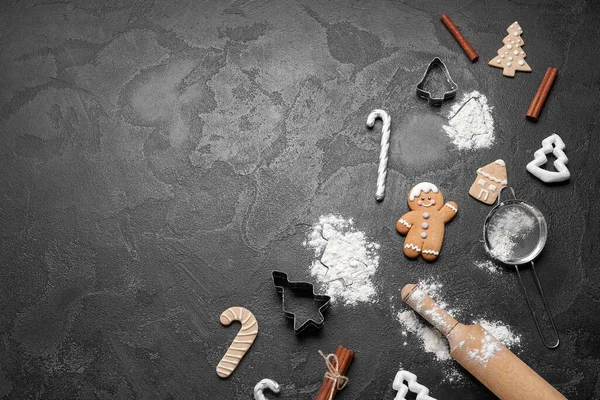Koyu arkaplanda Noel kurabiyeleri, dekorasyonlar ve mutfak gereçleri olan kompozisyon