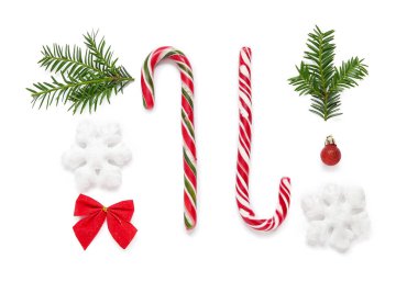 Beyaz arka planda Noel süslemeleri ve baston şekerlerle güzel bir kompozisyon