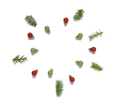 Beyaz arkaplanda Noel toplarından ve köknar dallarından yapılmış çerçeve