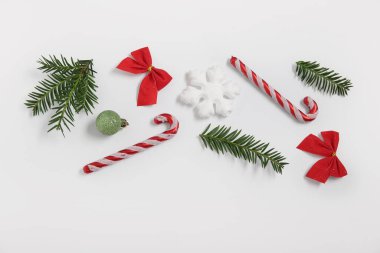 Şeker kamışları, köknar dalları ve beyaz arka planda Noel süslemeleri