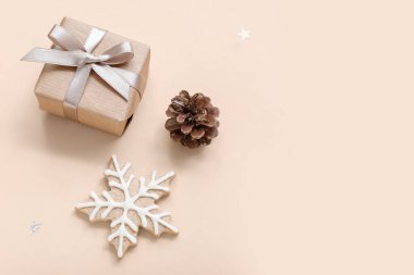 Bej arka planda Noel hediyesi kutusu, koni ve kurabiye.