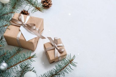 Noel ağacı dalları ve beyaz arka planda hediye kutuları