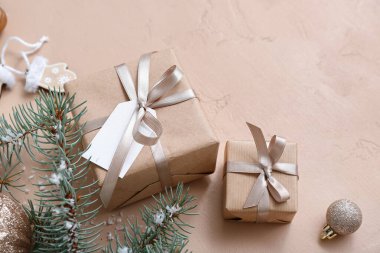 Noel ağacı dalları ve bej arka planda hediye kutuları