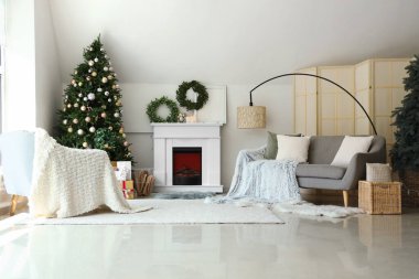 Noel ağacı ve şöminesi olan şenlikli oturma odasının içinde.