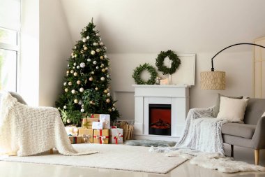 Noel ağacı ve şöminesi olan şenlikli oturma odasının içinde.