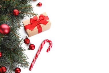 Hediye kutusu ve beyaz arka planda süslemeleri olan Noel ağacı dalları