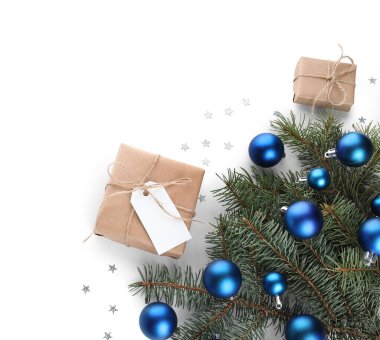 Beyaz arka planda Noel hediye kutuları ve topları olan dallar