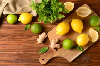 Tahta arka planda taze limonata hazırlamak için farklı malzemeler içeren pano.