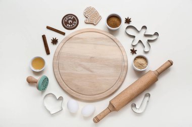 Gri arka planda Noel kurabiyeleri hazırlamak için içi boş ahşap tahta, malzeme ve çatal bıçak içeren kompozisyon