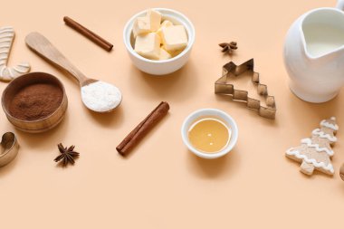 Renkli arka planda lezzetli Noel kurabiyeleri hazırlamak için malzemeler içeren kompozisyon