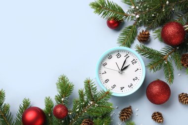 Alarm saati ve mavi arka planda topları olan Noel ağacı dalları