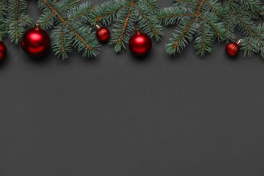 Noel topları ve koyu arkaplanda köknar dalları olan kompozisyon