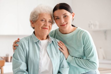 Kızıyla mutfakta sarılan son sınıf öğrencisi bir kadın.