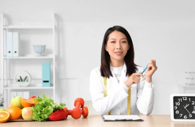 Masada çalışan Asyalı kadın beslenme uzmanı.