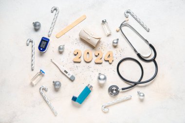 Şekil 2024 ve beyaz arka planda Noel dekoru olan doktor aletleri