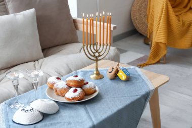 Table setting for Hannukah with donuts in living room clipart