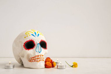 Kadife çiçekli mumlar ve beyaz arka planda boyalı kafatası. Meksika Ölüler Günü 'nün Kutlaması (El Dia de Muertos)